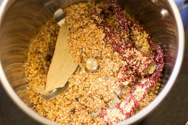 take the roasted whole spices in a grinder jar.