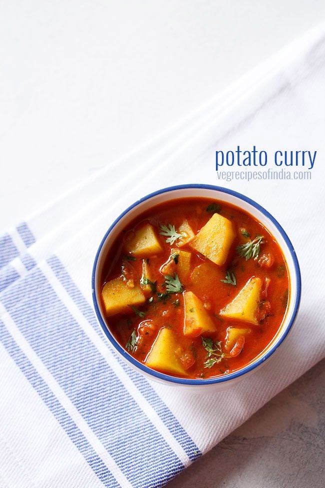 potato curry in a blue rimmed white bowl on a blue bordered white napkin
