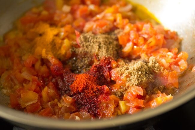 ground spices added to tomatoes for making potato curry