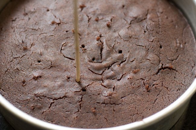 poking holes on cooked cake. 