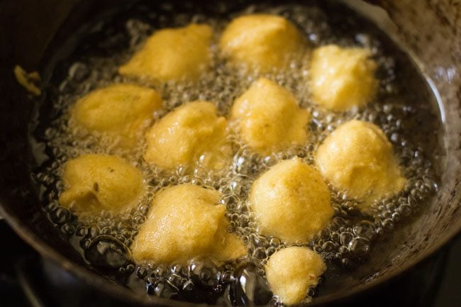 frying pakodas from the other side in hot oil. 