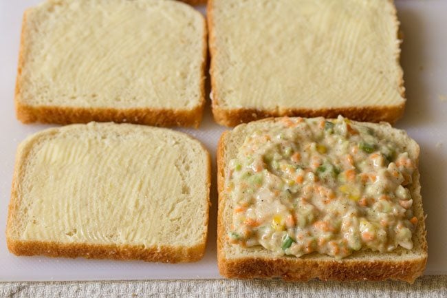 adding coleslaw stuffing on bread slice