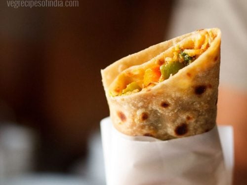 vegetarian kathi roll in a hand with text layover.