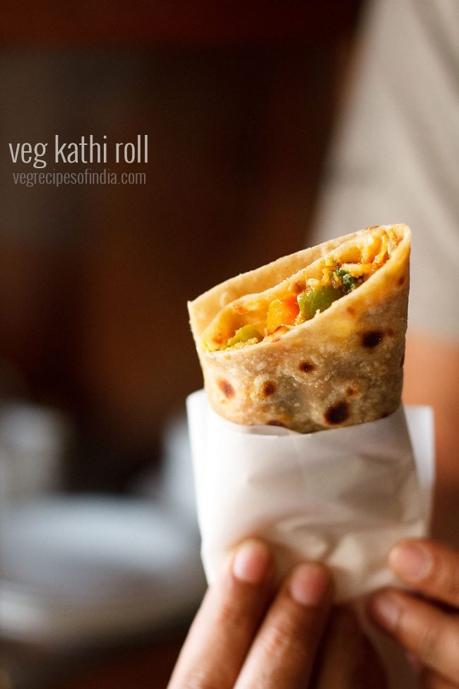vegetarian kathi roll in a hand with text layover.