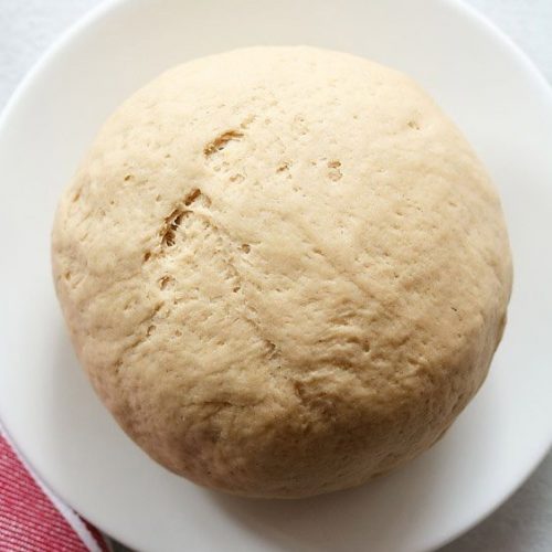 whole wheat pizza dough on a white plate.