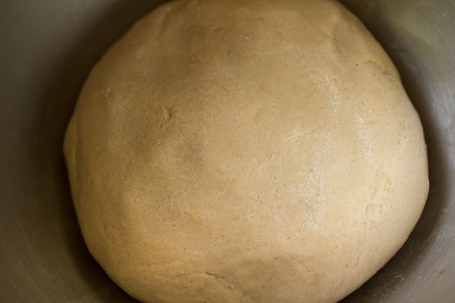 whole wheat pizza dough gathered into a ball and brushed with water for rising.