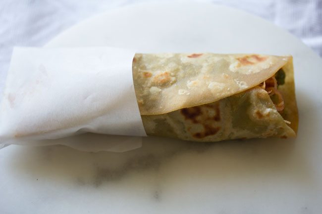 paneer roll in a piece of butter paper for eating.