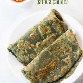 two folded bathua paratha on white plate with a small bowl of amla pickle.