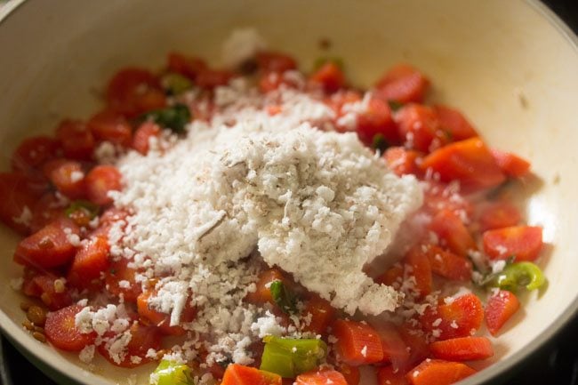 grated coconut added to carrots in the pan