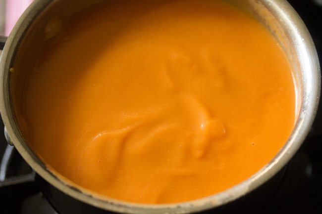 adding water and heating up the carrot ginger soup on the stovetop. 