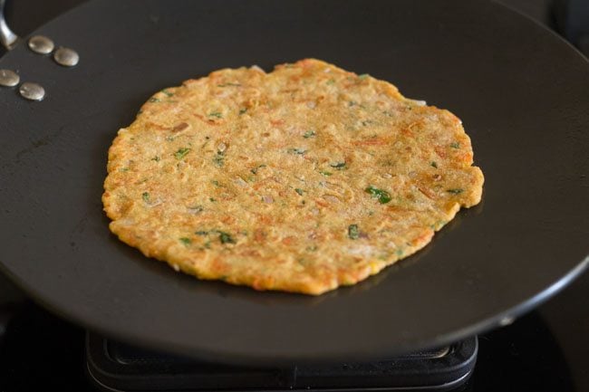 cooking carrot paratha on hot tawa