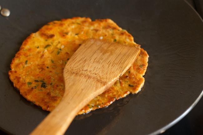 flipped and cooking second side of carrot paratha