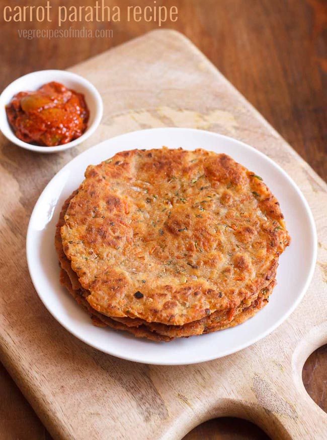 carrot paratha served on a white plate with a side of pickle