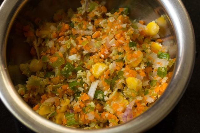 finely chopped mixed vegetables and steamed corn kernels added to a bowl for making the sandwich stuffing. 