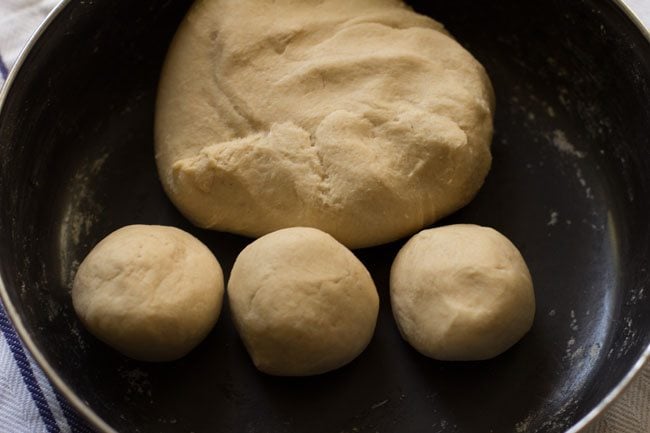 atta dough in one large ball and three small balls for turning into roti.