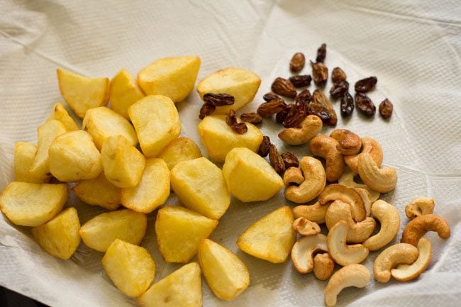 fried potatoes, fried cashews and fried raisins kept on kitchen paper towel. 