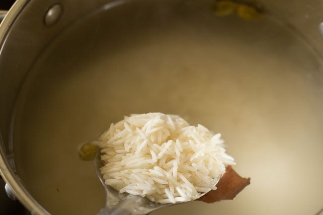 adding soaked rice to the boiling water. 