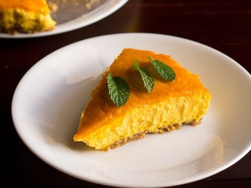 one slice of mango cheesecake on a white plate