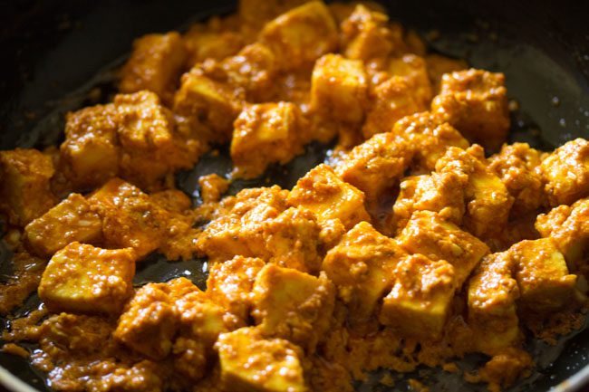 close up shot of cooked paneer tikka in a pan.