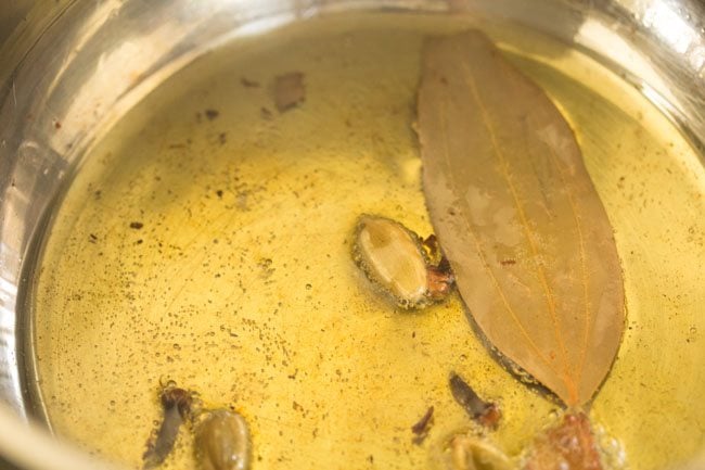 sautéing spices in hot ghee in pan. 