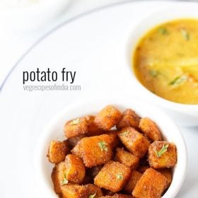 potato fry served in a bowl placed on a white plate with lentil curry in another bowl