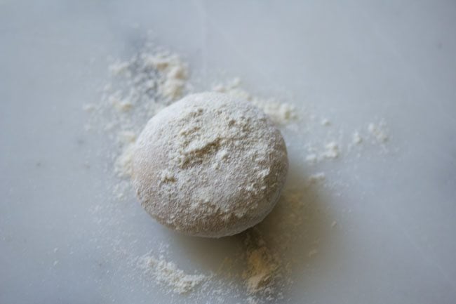 dusting dough ball with flour for rolling.