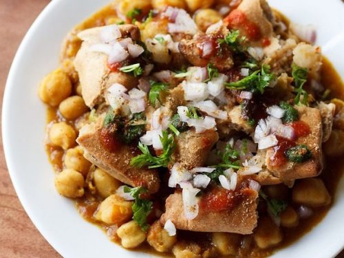 samosa chaat served on a white plate.