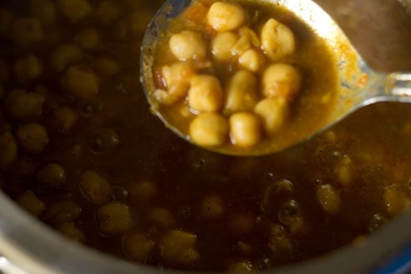 cooked chana masala in a spoon
