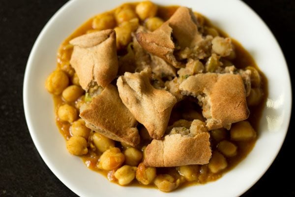 samosa added to chana masala on plate