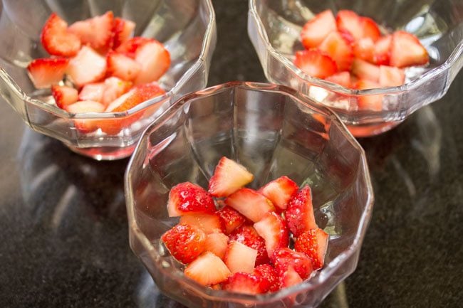 macerated strawberries added to serving bowls. 