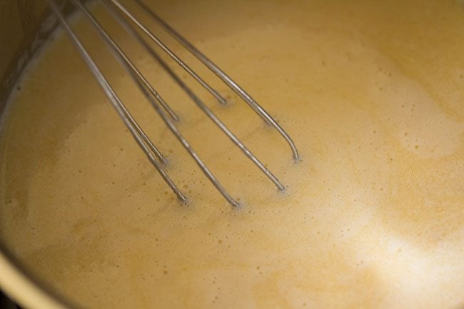 stirring milk mixture for white sauce recipe. 