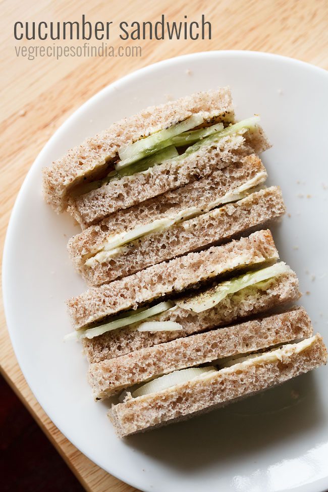 close up shot of stacked cucumber sandwiches with the visible layers of cucumber and bread placed on a white plate