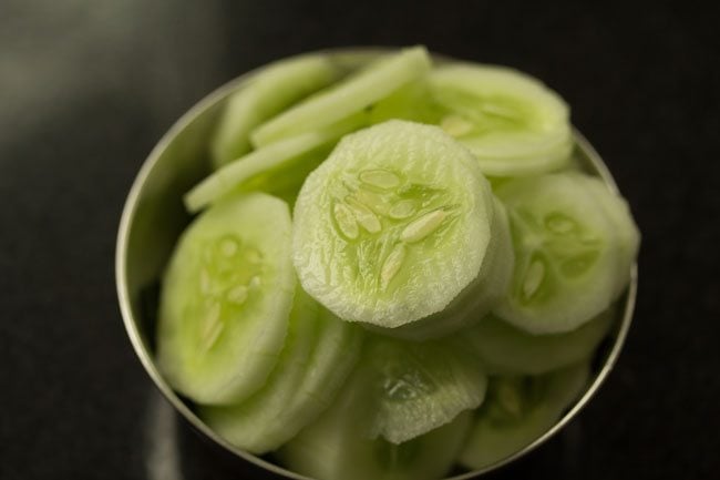 heaped thinly sliced cucumber in a steel bowl to make cucumber sandwich