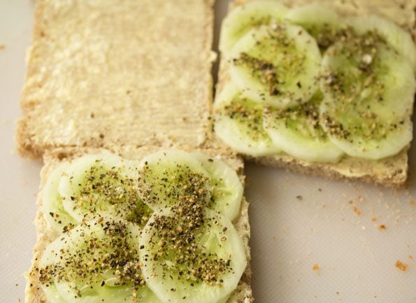 freshly cracked black pepper and salt sprinkled on cucumber slices on top of the bread