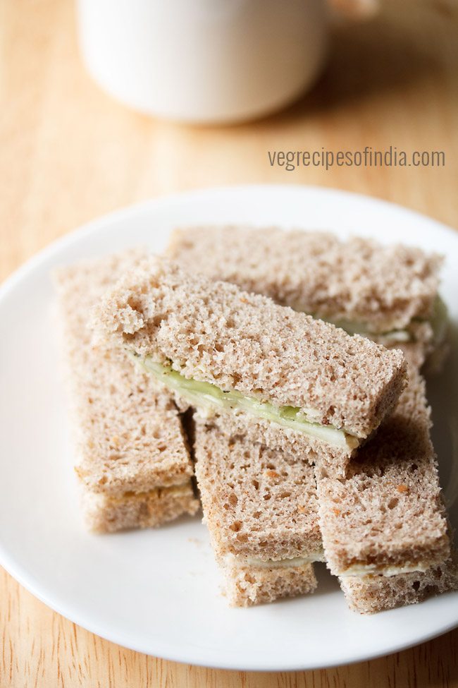 close up shot of cucumber sandwiches on a white plate