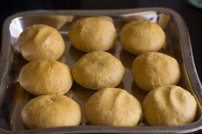 balls made from dough and kept aside on a squared steel tray. 