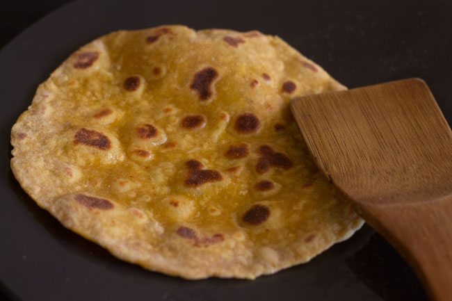 sides being pressed with a wooden spatula. 