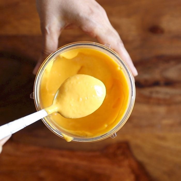 mango and condensed milk mixture being shown with a spoon