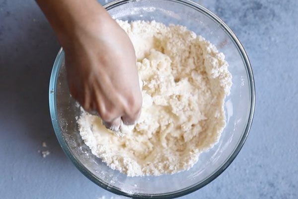 flour being mixed with water and kneaded.