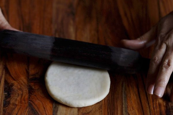 khasta kachori being rolled with a rolling pin. 