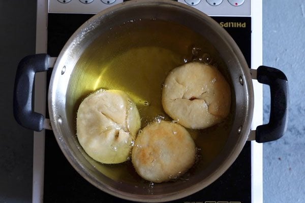 kachori being fried in oil in kadai. 