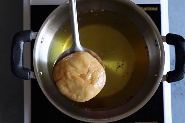 kachori on a slotted spoon.