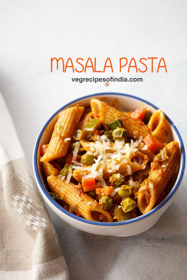 masala pasta garnished with grated cheese and served in a blue rimmed ceramic bowl with text layovers. 