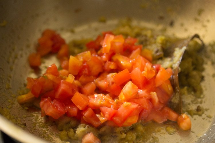 chopped tomatoes added to mixture in the pan