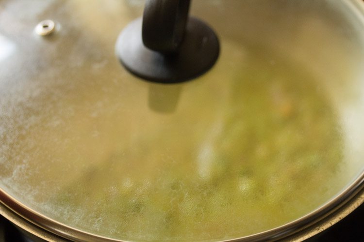 simmering matar ka nimona curry with lid kept on pan