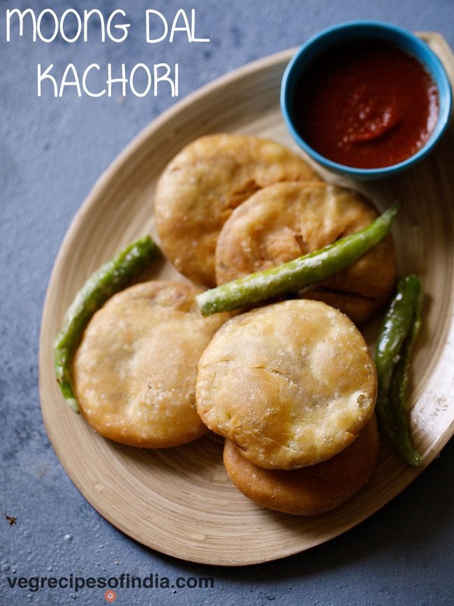 moong dal kachori  in a tray with green chillies on top. 