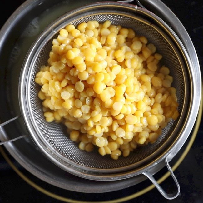 straining cooked chana dal for making sweet stuffing for obbattu recipe. 