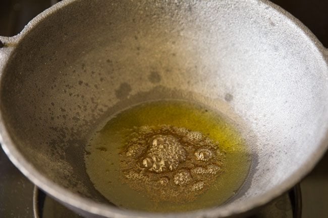 mustard seeds added to hot ghee in pan. 