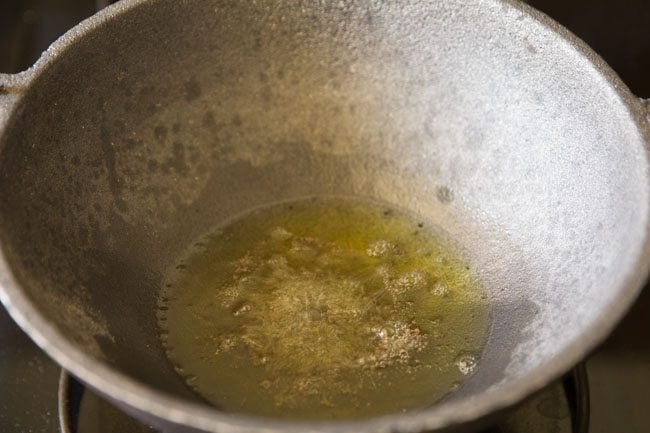 mustard seeds spluttering in hot ghee in pan. 