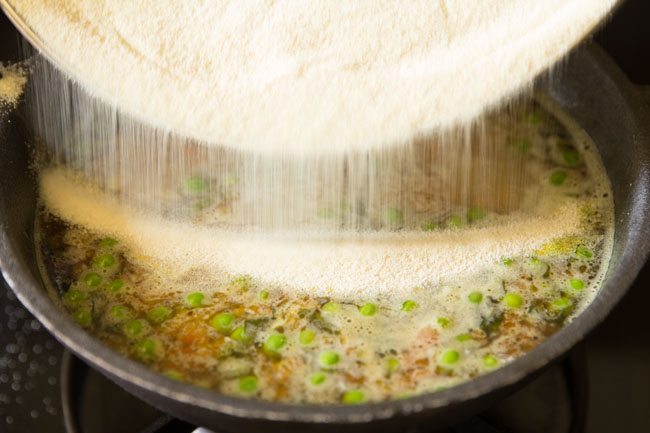 adding roasted rava in pan. 